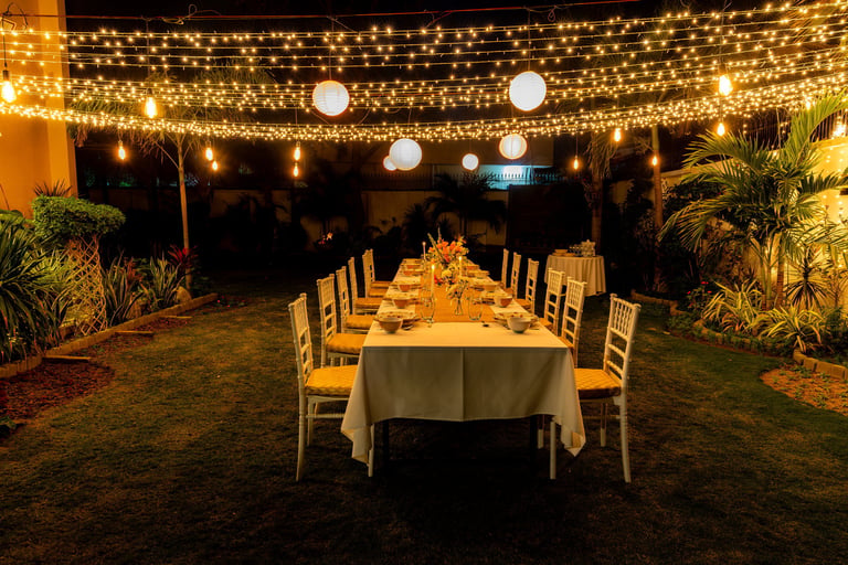Cena elegante con luces y decoración en jardín