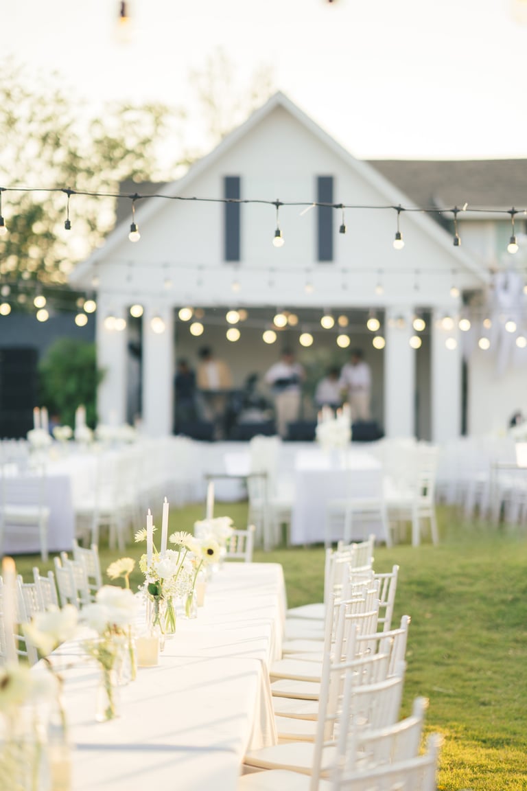 Elegante boda al aire libre en jardín con mesa decorada con velas y rosas blancas