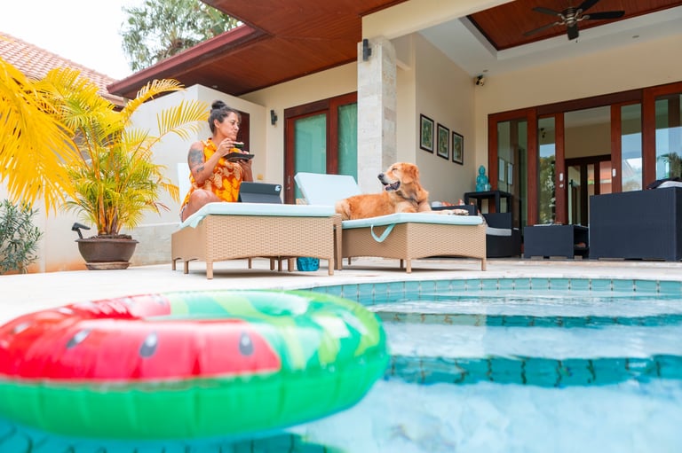 Mujer relajándose junto a piscina tropical con su perro