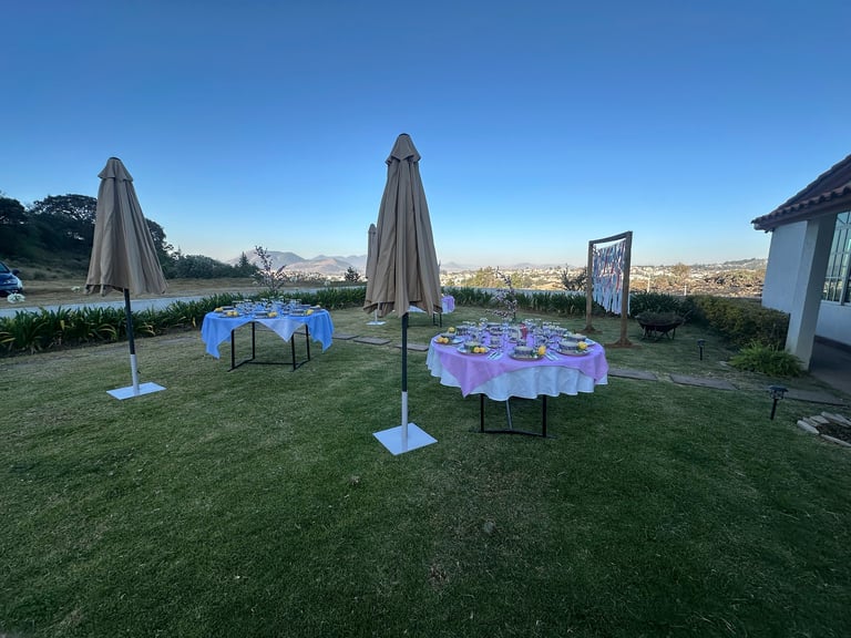 Instalación de eventos con mesas de colores en jardín verde