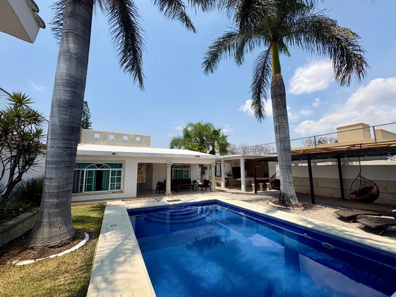 Casa moderna beige con alberca azul