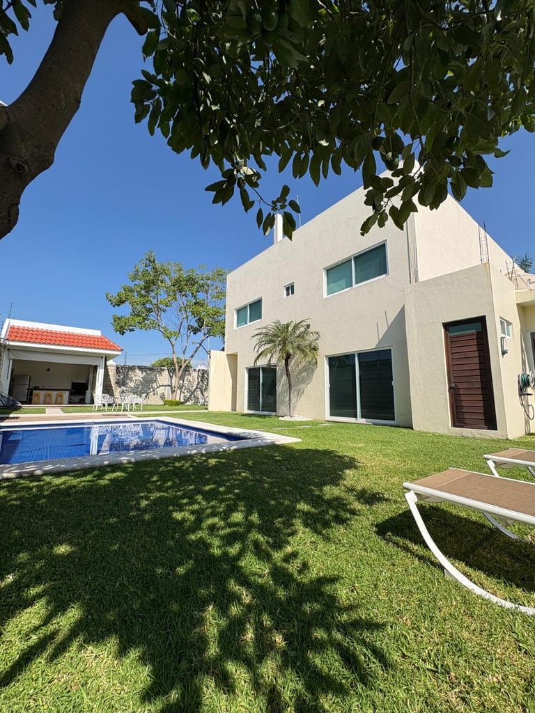 Modern white house with pool and green lawn