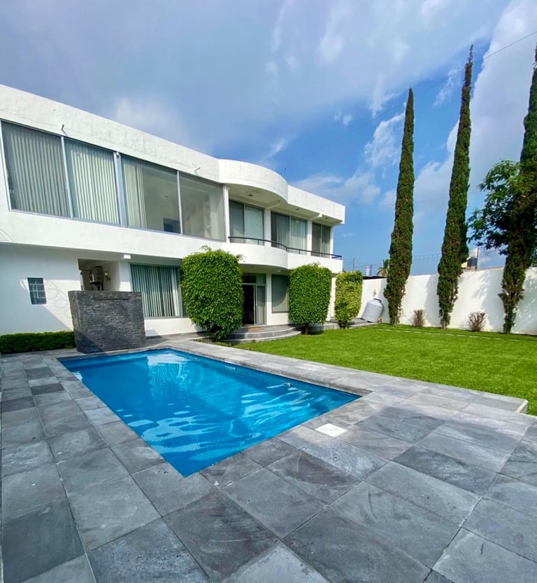 Modern white house with swimming pool and cypress trees